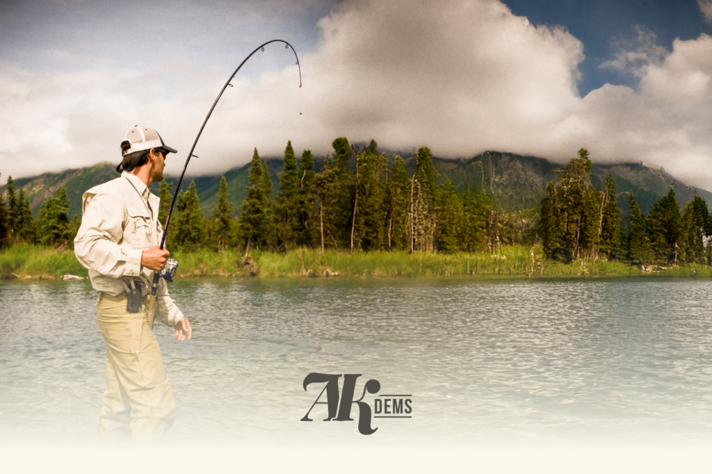 Man fishing in a river with a curved rod, forested mountains in the background; Alaska Democrats logo at the bottom.