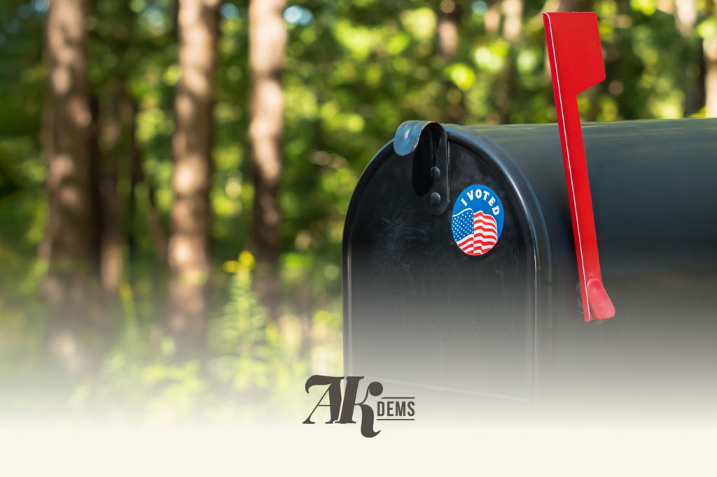 Close-up of a black mailbox with a raised red flag and an 'I Voted' sticker featuring the American flag.
