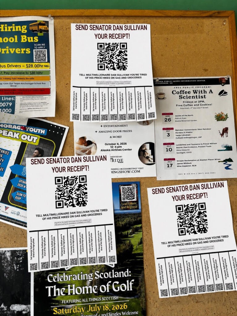 Corkboard covered with flyers and posters, including several 'Send Senator Dan Sullivan Your Receipt' sheets with large QR codes.